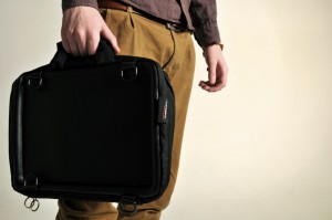 Image of a young man carrying the Trabasack Mini in hand as a briefcase