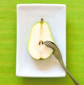 Image of Knork cutting through a sliced pear on a green background