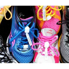 Photograph of several different sports shoes of different styles, fitted with brightly-coloured Greeper Sports shoe laces