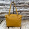 Image shows a photograph of a ladies shoulder bag in a bold Mustard yellow colour in front of and atop a wooden background