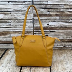 Image shows a photograph of a ladies shoulder bag in a bold Mustard yellow colour in front of and atop a wooden background
