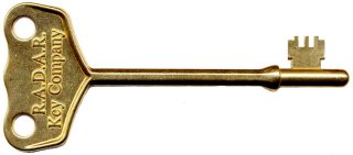 Image of a large-headed brass RADAR key lay flat, lengthways, on a white background