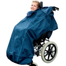 Image shows a photograph of a boy smiling towards the camera, sat in a wheelchair wearing a Seenin navy blue total waterproof cover