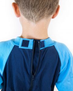 Image shows a photograph of the back of a boy's neck wearing the Seenin sleepsuit in navy and turquoise