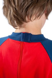 Image shows a photograph of the back of a boy's neck and shoulders, to illustrate the velcro-covered back zip of the Seenin jersey sleepsuit in navy and red