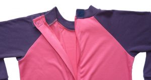 Image shows a photograph of the back of a Seenin sleepsuit in pink and purple, with the back neck area open and unzipped