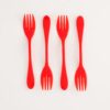 Image is a photograph of 4 red, plastic Knorks top-to-tail in a line, lay flat on a white background