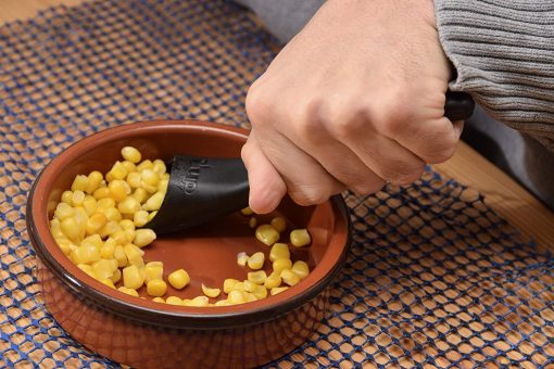 Image is a photograph of the S'Up Spoon being used to scoop-up sweetcorn