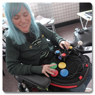 Image is a photograph of Sasha using the Curve Connect to play video games using switches and a joystick