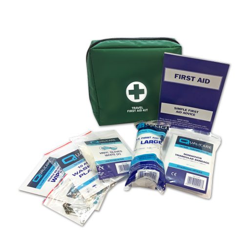 Image is a photograph of a green first aid kit bag, with various first aid contents around it